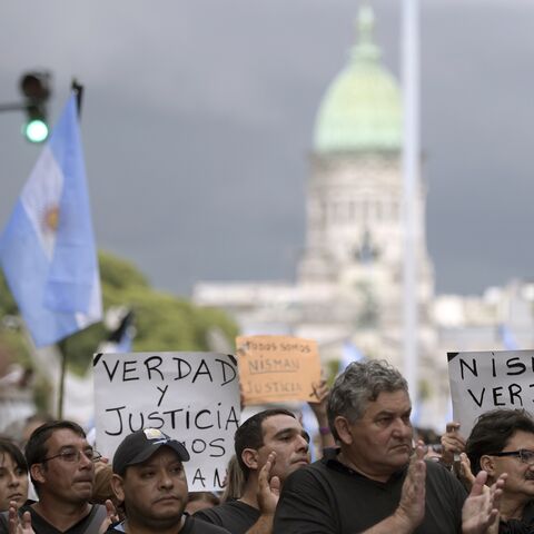 People rally near the Congress building before marching along Avenida de Mayo avenue in the "Marcha del silencio"(March of Silence) called by Argentine prosecutors in memory of their late colleague Alberto Nisman in Buenos Aires on February 18, 2015. President Cristina Kirchner urged Argentines to be on guard Wednesday ahead of a mass protest over the mysterious death of Nisman who had accused her of a cover-up in his probe of a 1994 bombing. Nisman was found in his Buenos Aires apartment with a bullet thro
