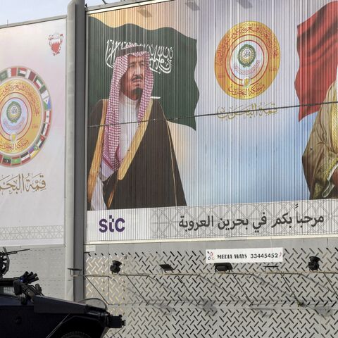 A Bahrain security forces armored vehicle is stationed near a billboard depicting the faces of Saudi Arabia's King Salman bin Abdulaziz (L), last year's Arab League summit host, and Bahrain's King Hamad bin Isa Al Khalifa (R), this year's host,  ahead of the 33rd league summit in Manama, May 15, 2024. 